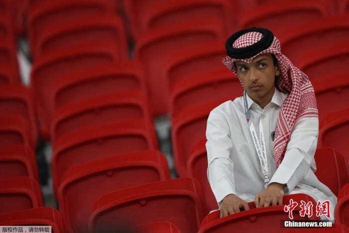 一名卡塔爾隊的小球迷站在看臺上，神情沮喪。
