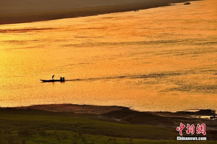 资料图：初秋时节黄昏时分打渔人划船在长江中。石伟 摄