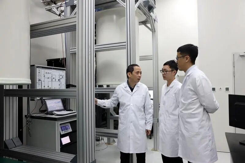 中國科學技術大學教授、“祖沖之號”量子計算總師朱曉波（左一）與學生討論實驗結果。新華社資料